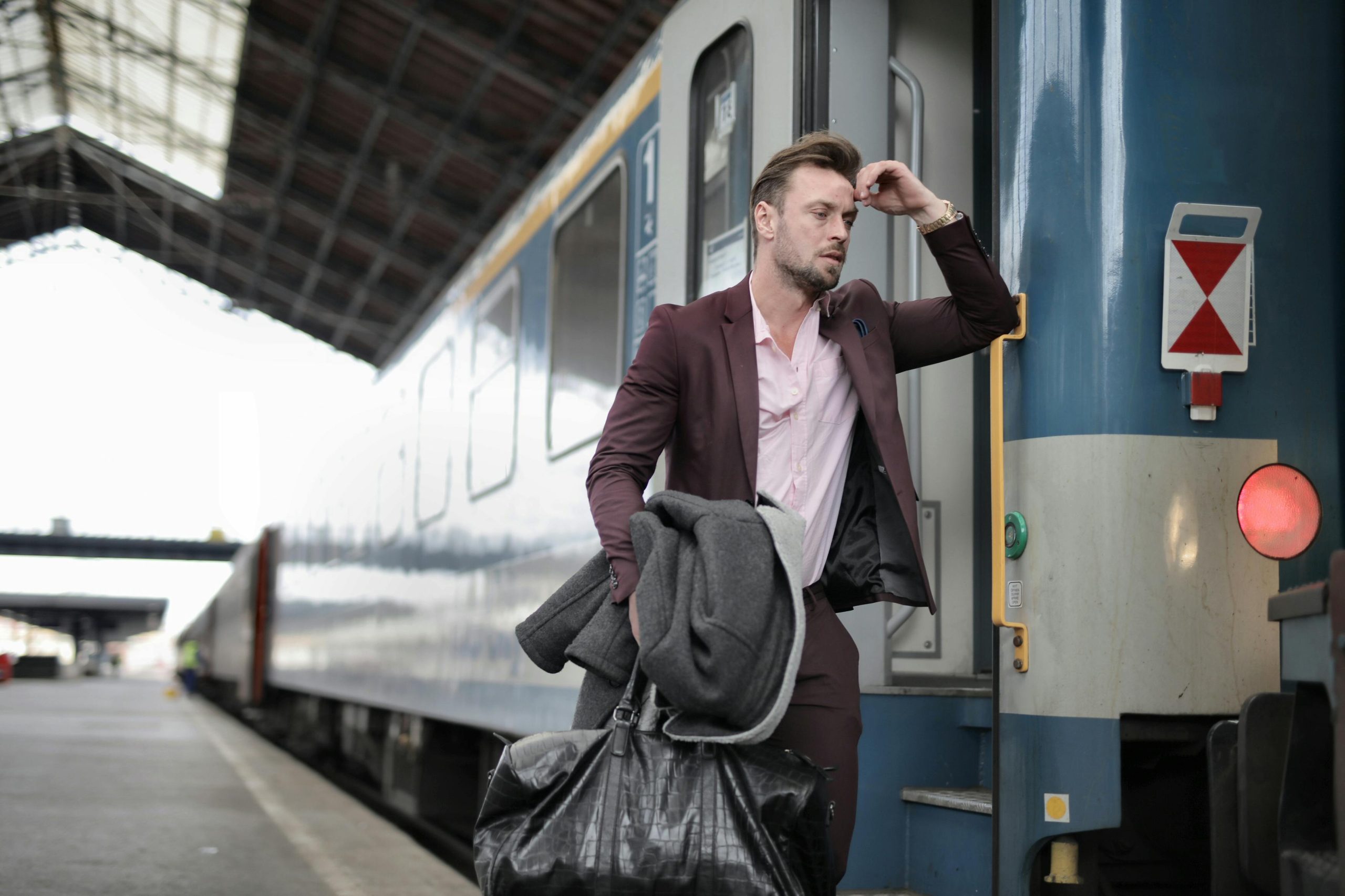 man experiencing travel anxiety standing next to a train