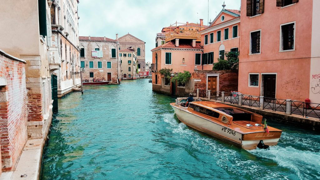 wooden boat traversing a Venice canal without travel anxiety